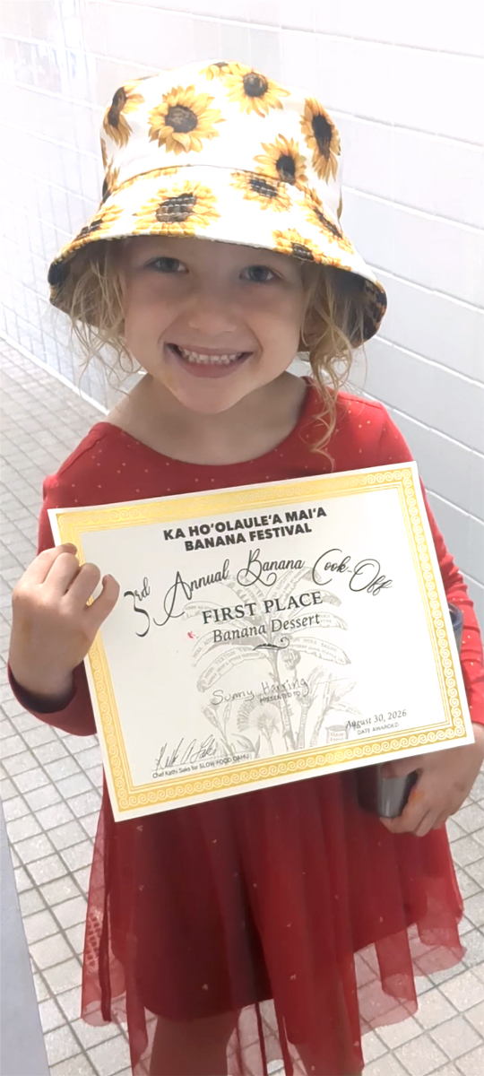 Sunny Harrington proudly displays her certificate for winning first place in the Banana Dessert category