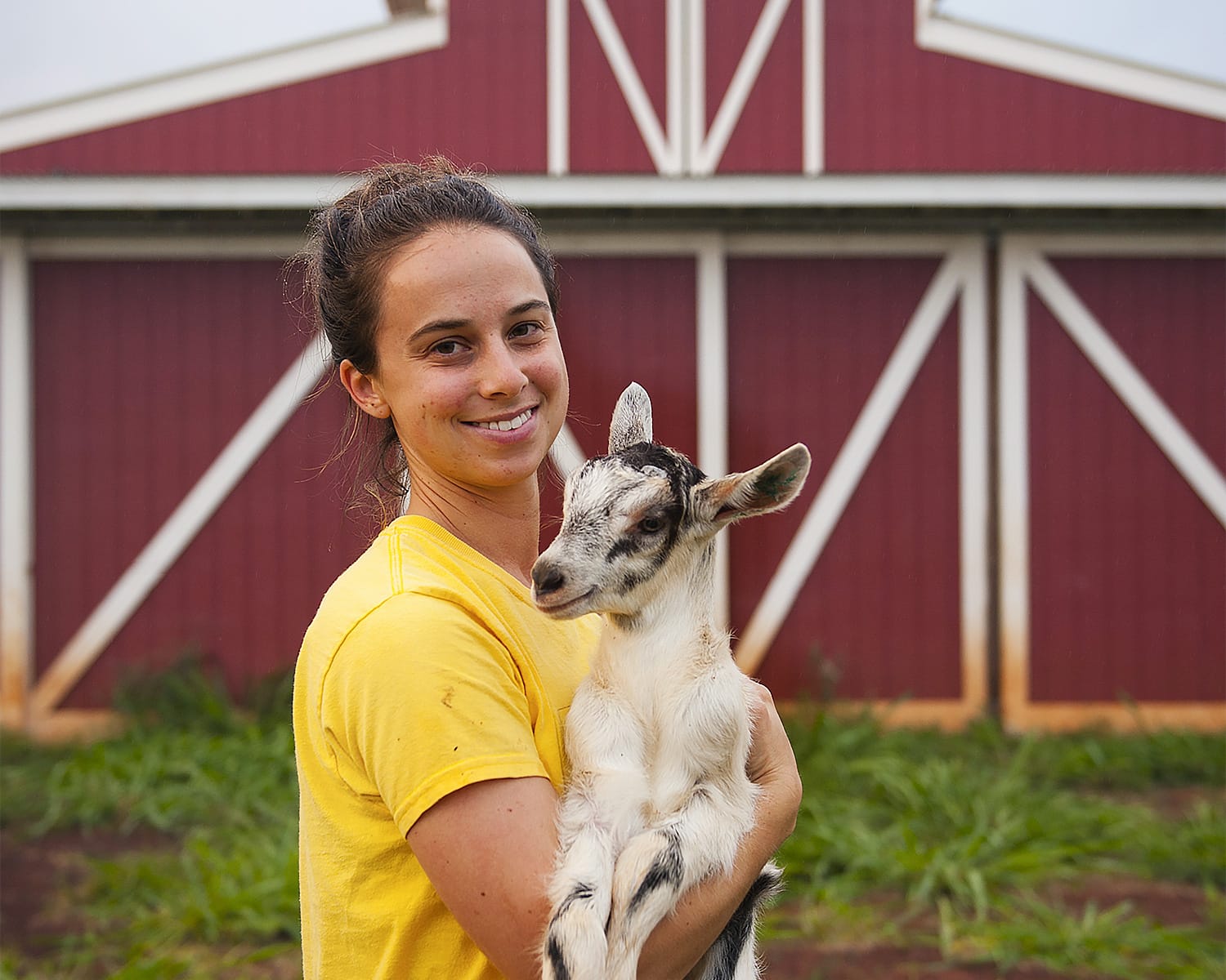 Emma Bello McCaulley with a goat at Sweet Land Farm